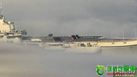 ÕýÔÚ»º»ºÈë¸ÛµÄÍßÁ¼¸ñº½Ä¸£¬Æä¼×°åÉϵÄÁ½¿é¹©½¢ÔØ»úÆð½µÊ¹Óõĵ²Ñæ°åÊúÆð